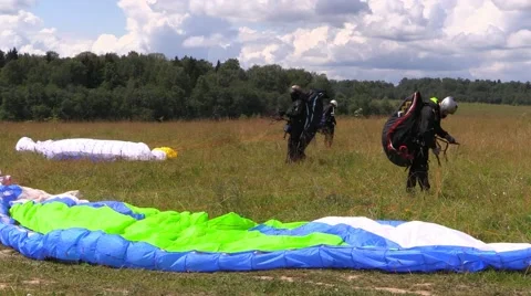 Paragliders wait wind to fly over field Stock Footage 52364454