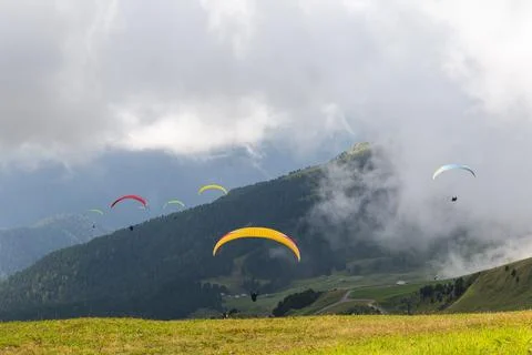 Paraglides between clouds and ground grass Stock Photos
