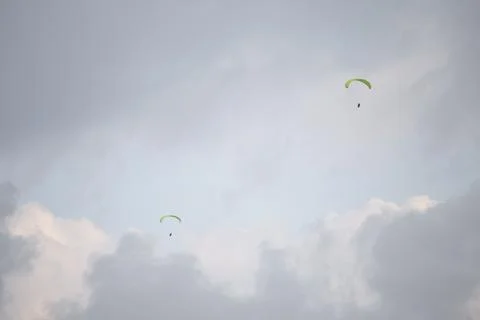 Paraglides on the cloudy sky Stock Photos