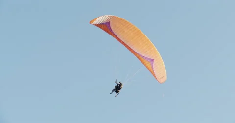 Paragliding against clear blue sky with instructor pilot Stock Footage 159567452