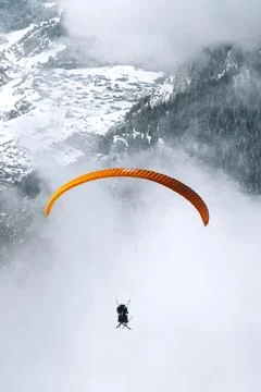 Paragliding on a cloudy day through the mountain 스톡 사진