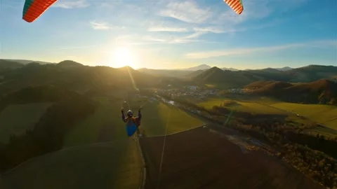 Paragliding flight above green spring countryside nature at golden sunset flying 库存影片 265189795