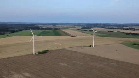 Paragliding flight around large wind turbine in open landscape aerial adventure 스톡 동영상 334685770