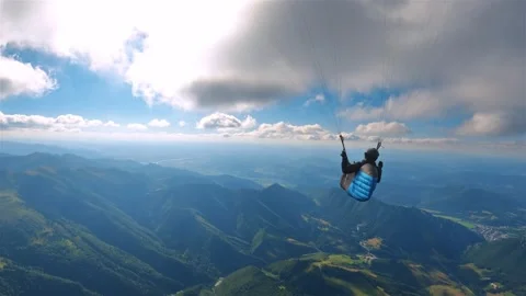 Paragliding flying high in clouds above green mountains Stock Footage 307638245