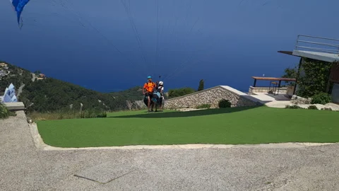 Paragliding instructor and client taking off and gliding into the distance. Stock Footage 244935130