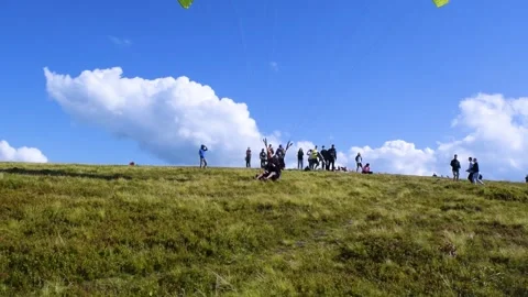 Paragliding instructor with passenger landing after paragliding flight. Stock Footage 258945809