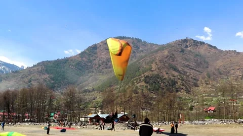 Paragliding landing at plan surface in valley from unique angle Stock Footage 138802663