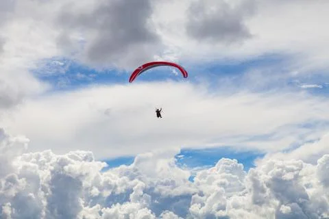 Paragliding in the massive cloudy sky 스톡 사진