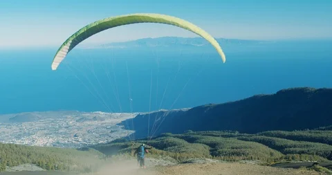 Paragliding, with pilot adjusting wing controls, changing direction. 스톡 동영상 124560603