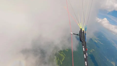 Paragliding pilot flying in fluffy storm clouds and turning fast in summer Video stock 258379894
