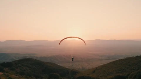 Paragliding pilot flying straight into the sun. Peaceful flight with a Vídeo Stock 266117652