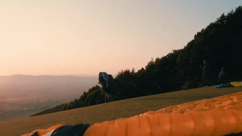 Paragliding pilot takes off from a flying start on a mountain at sunrise. Video stock 266781500