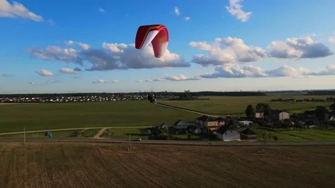 Paragliding in tandem over flat fields in sunny weather Stock Footage 196033035