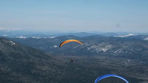 Paragliding in winter against the backdrop of snow-capped mountains covered with Stock-Footage 89854748