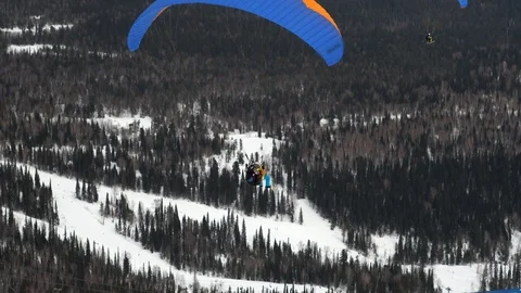 Paragliding in winter against the backdrop of snow-capped mountains covered with Stock-Footage 89855485