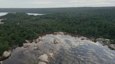 Parallax of clouds against the reflection across the lake seen by drone Stock Footage 237919029