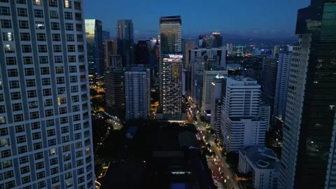 Parallax drone movement through Manila skyline transitioning from sunset into Vídeos de archivo 328593143