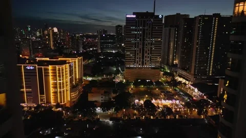 Parallax drone movement through Manila skyline transitioning from sunset into Stock Footage 328593949