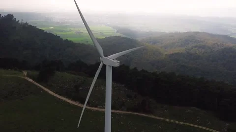 Parallax drone pullback shot revealing a wind turbine at the Parco Eolico di Stock Footage 334266734