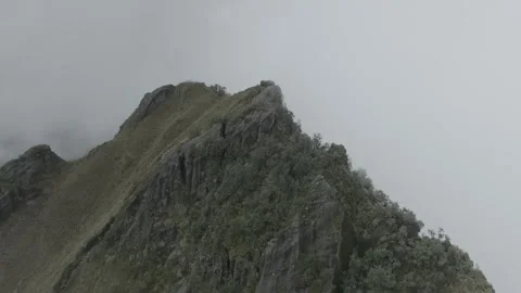 Parallax drone view of top of a mountain with clouds covering it. Stock Footage 269472732