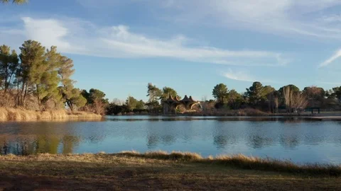 Parallax effect with reflections on a park lake as clouds roll by Stock Footage 104431177