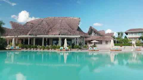 Parallax shot of resort pool with thatch roof buildings at the background Stock Footage 235420585