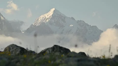 Parallax in sliding. Snow-capped mountain peak rises above clouds with rocky Stock Footage 341474938