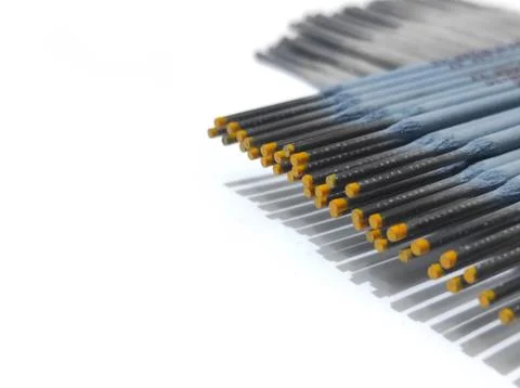 Parallel arrangement of welding electrodes on a white surface. Stockfoto's