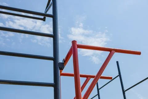 Parallel bars stand in a gym environment under a bright blue sky, inviting .. Stock Photos