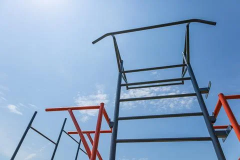 Parallel bars stand tall against a vibrant blue sky, creating a perfect spo.. Stock Photos