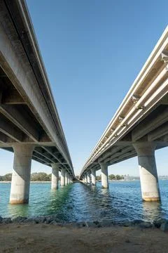 Parallel bridges over a river under a clear blue sky Stockfoto's