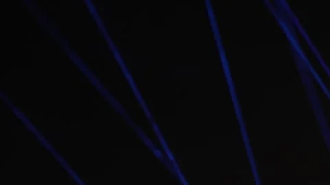 Parallel bright blue laser beams shining through complete pitch darkness. Stock Footage 344025180