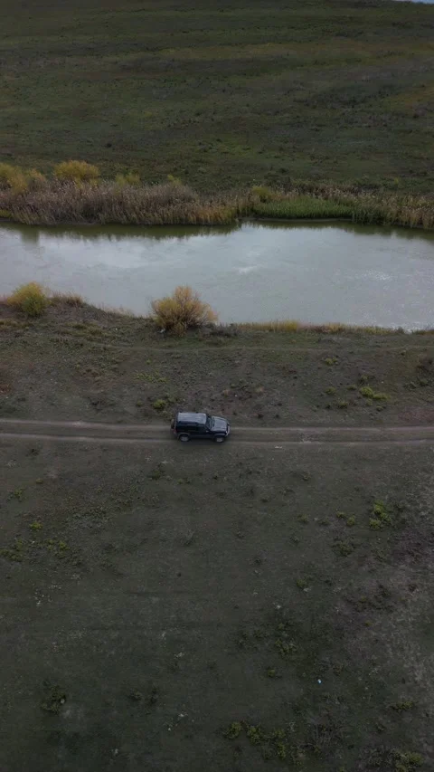 Parallel drone shot flying beside car with river on opposite side Stock Footage 334330816
