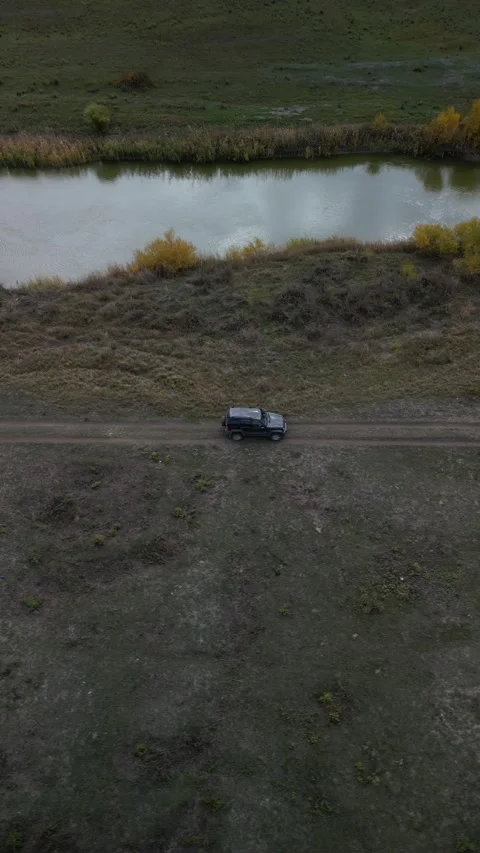 Parallel drone shot flying beside car with river on opposite side Stock Footage 334330822