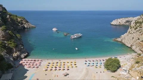 Parallel Drone View of Achata Beach, Karpathos with Swimmers, Sunbeds and Stock Footage 315690472