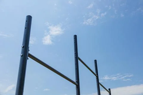 Parallel horizontal bars stand under a bright sky, providing a space for at.. Stock-Fotos