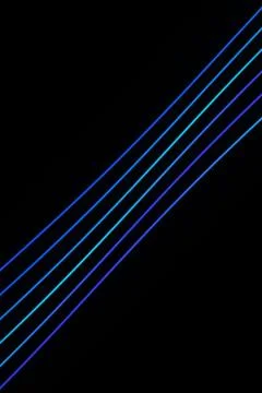 Parallel luminous blue and cyan lines rise diagonally across a black backgr.. Stock Illustration