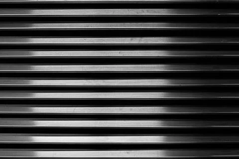The parallel metal bars of the ventilation grille create a repeating pattern Stock Photos