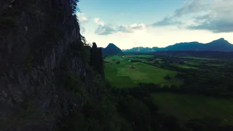 Parallel to mountain range Drone fly into green rice valley, Laos Stock Footage 289509825
