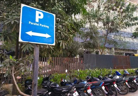 Parallel parking sign board with parallel parked two wheelers Stock Photos