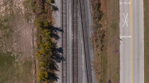 Parallel railroad tracks and roadway across open land in Gentry, Arkansas Stock Footage 345341661
