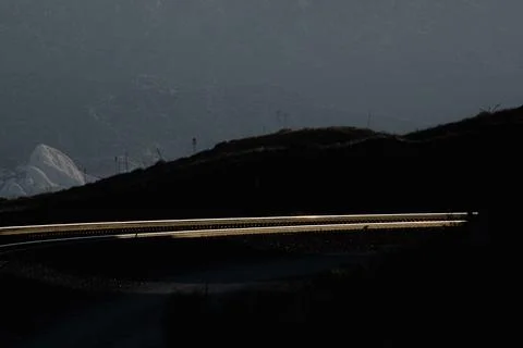 Parallel railroad tracks highlighted by setting sun in shadow 库存照片