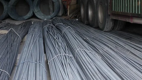 Parallel rows of metal rods line the floor of a supply area near pipes and beams Stock Footage 312781521