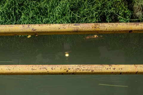 Parallel rusty iron railings at night over canal water surface Stock Photos