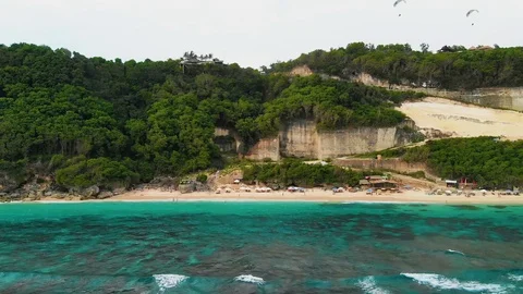 Parallel shot of beautiful green cliffs and golden sand beach, Pantai Stock Footage 106887883