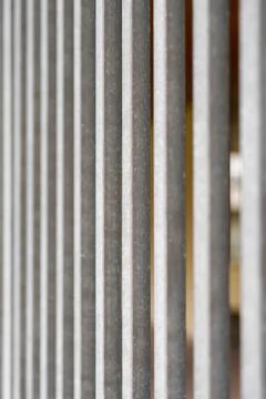 Parallel vertical geometric lines of a galvanized house yard fence lattice. A Foto stock