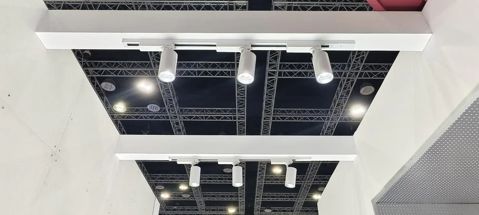 Parallel white beams supporting multiple cylindrical track lights Fotos Stock