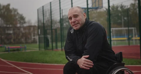 Paralympian man with disabilities not functioning legs look looking at camera Stock Footage 154249946