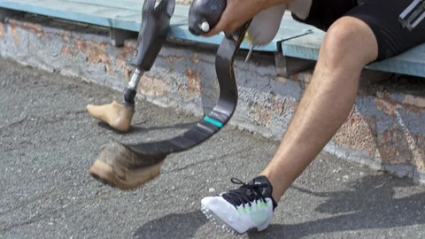 Paralympic Athlete Putting on Runner Blade Stock Footage 99768418