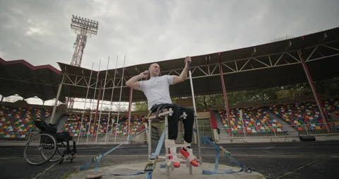 Paralympic disabled man with non-functioning legs trains sitting on a seat mount Stock-Footage 154250546